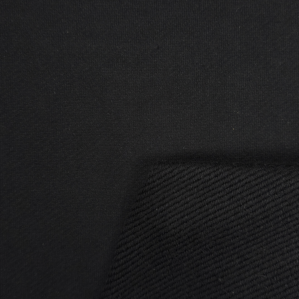 Detailaufnahme des dichten, diagonal gestrickten Heavy-Sweatstoffs mit matter Oberfläche und sichtbarer Textur.